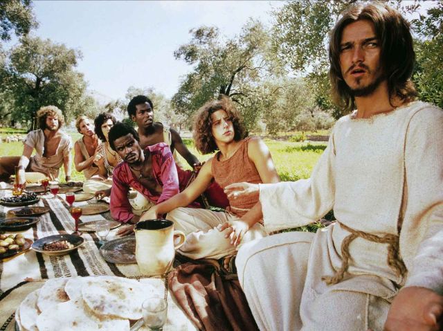 Scene of the 1973 film of Jesus Christ Superstar, with Ted Neeley as Jesus Christ (far right) and Carl Anderson as Judas Iscariot (third from right)